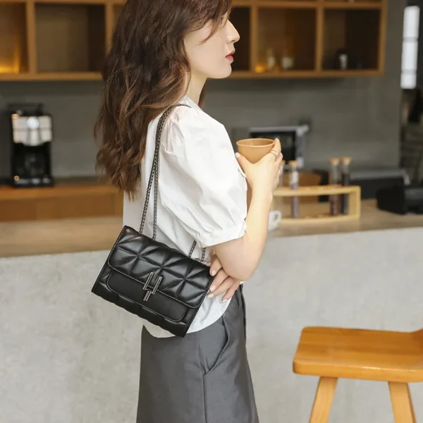 Woman with black handbag holding coffee cup.