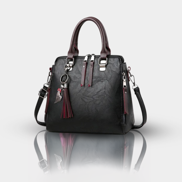 Black handbag with tassels and detachable strap.