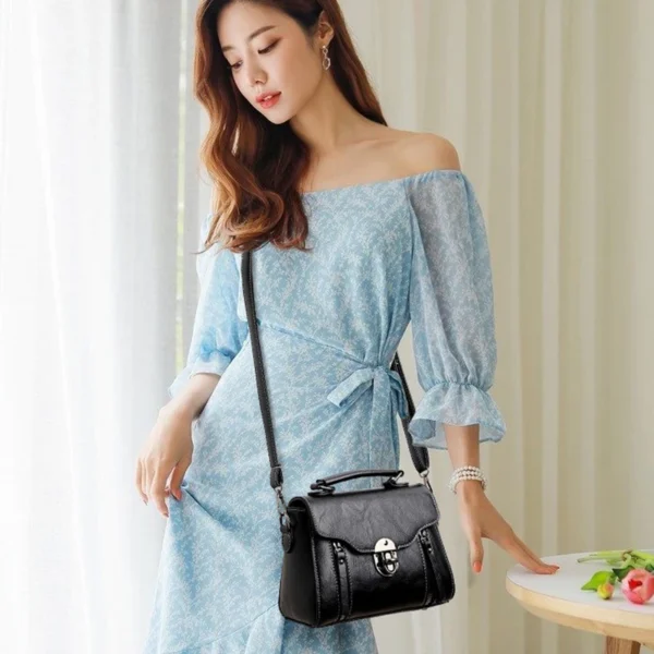 Woman in blue dress holding black handbag