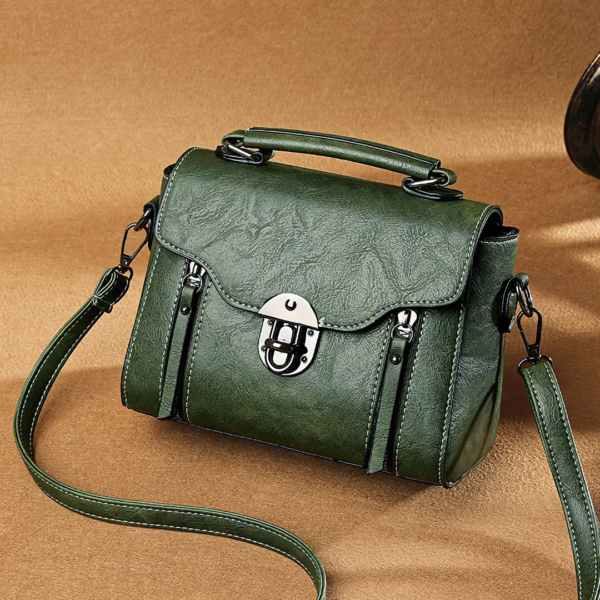 Green leather handbag with handle and strap.