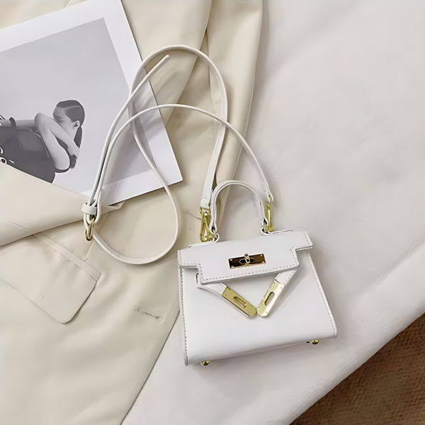 Elegant white handbag on cream-colored fabric.