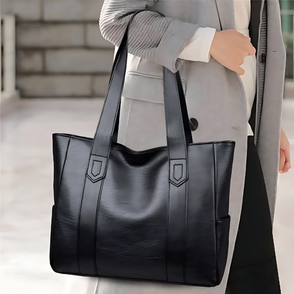 Woman holding black leather tote bag