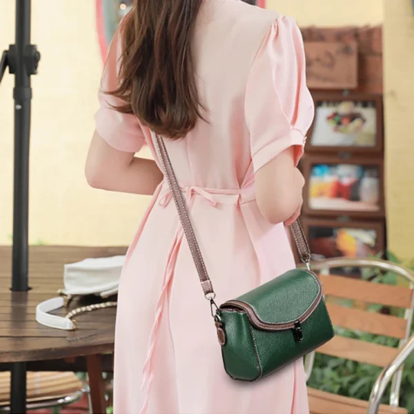 Woman in pink dress with green handbag.