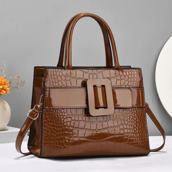 Brown crocodile leather handbag with buckle detail.